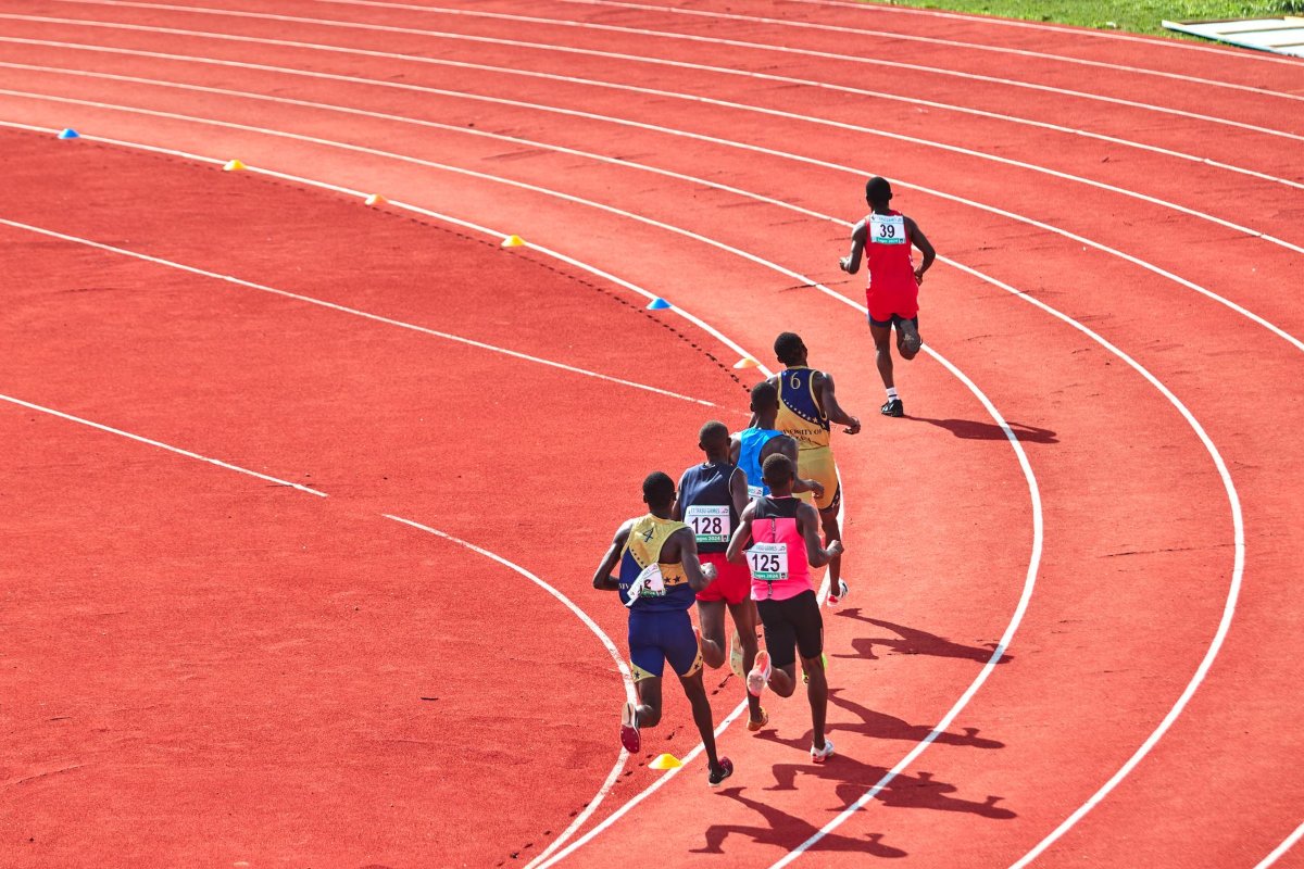 Atletas competindo em uma pista de atletismo ao ar livre