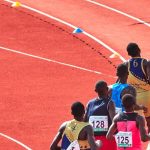 Atletas competindo em uma pista de atletismo ao ar livre