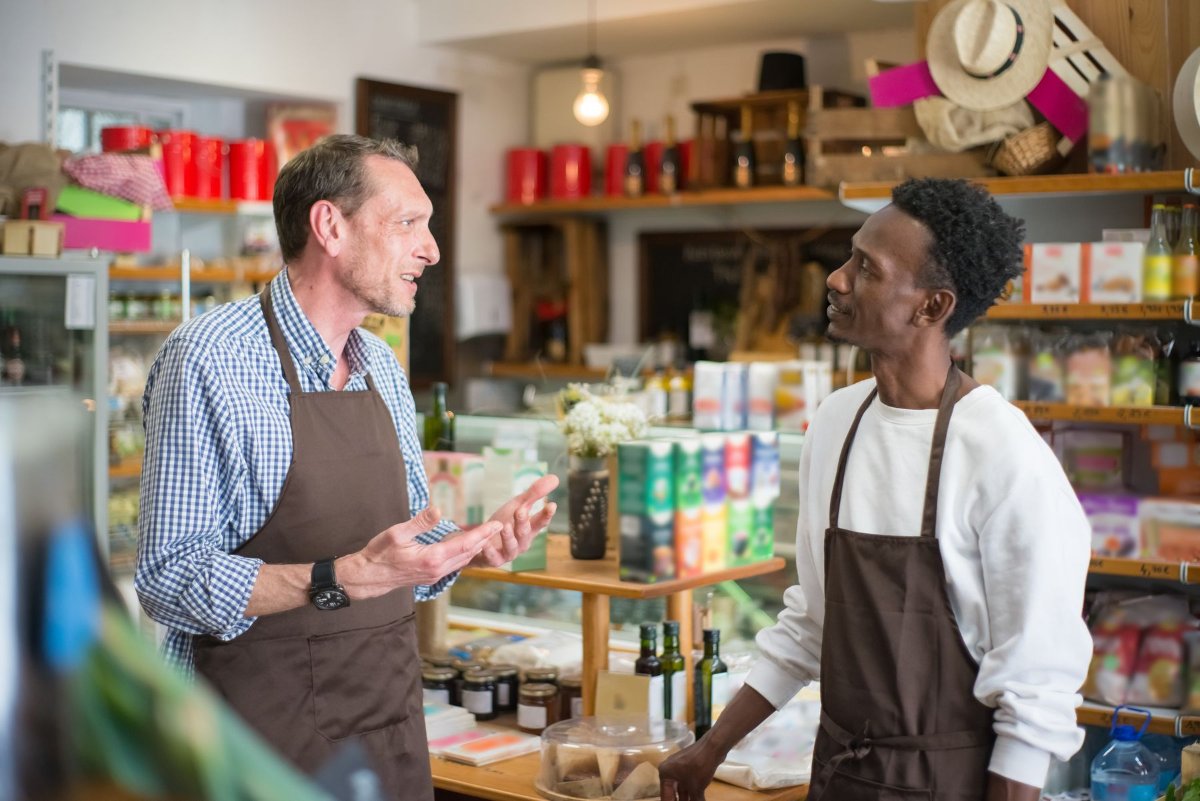 Dois trabalhadores conversando dentro de um mercado