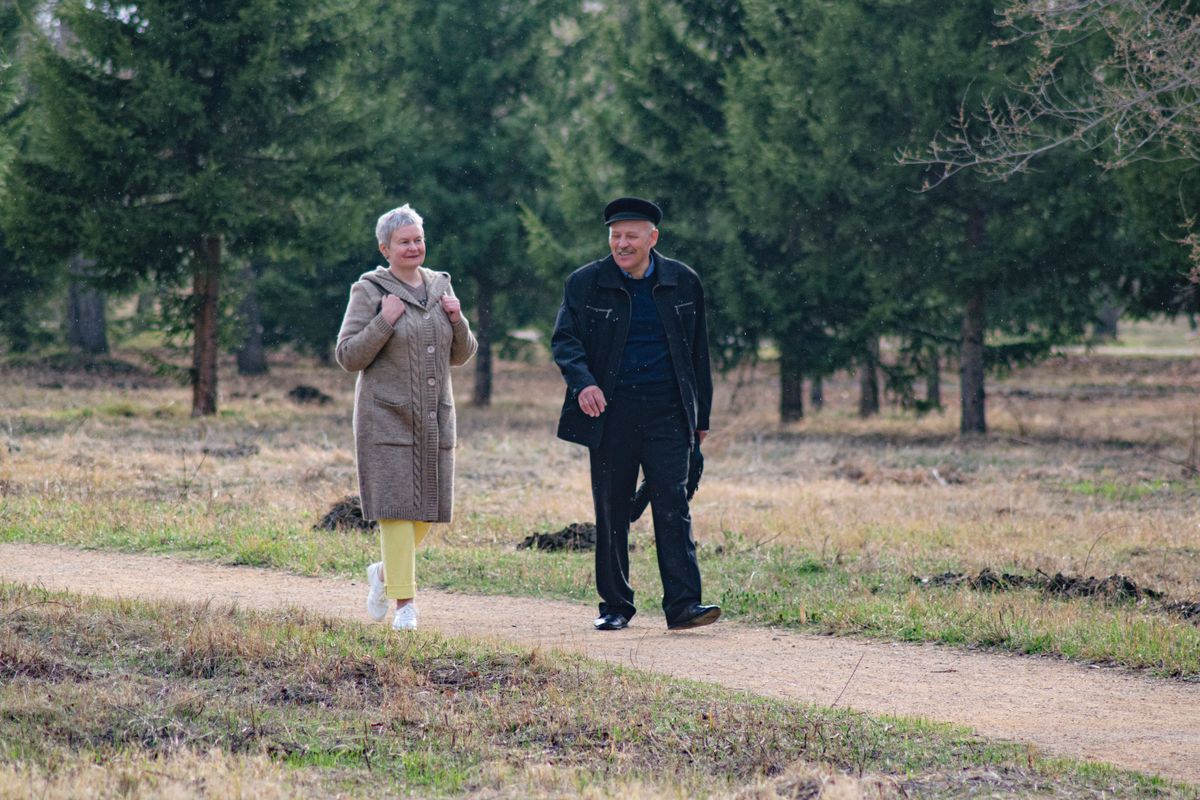 Casal de idosos caminhando em um parque, ilustrando a idade mínima progressiva da aposentadoria