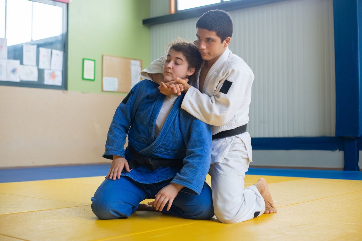 Homem e mulher treinando judô no tatame