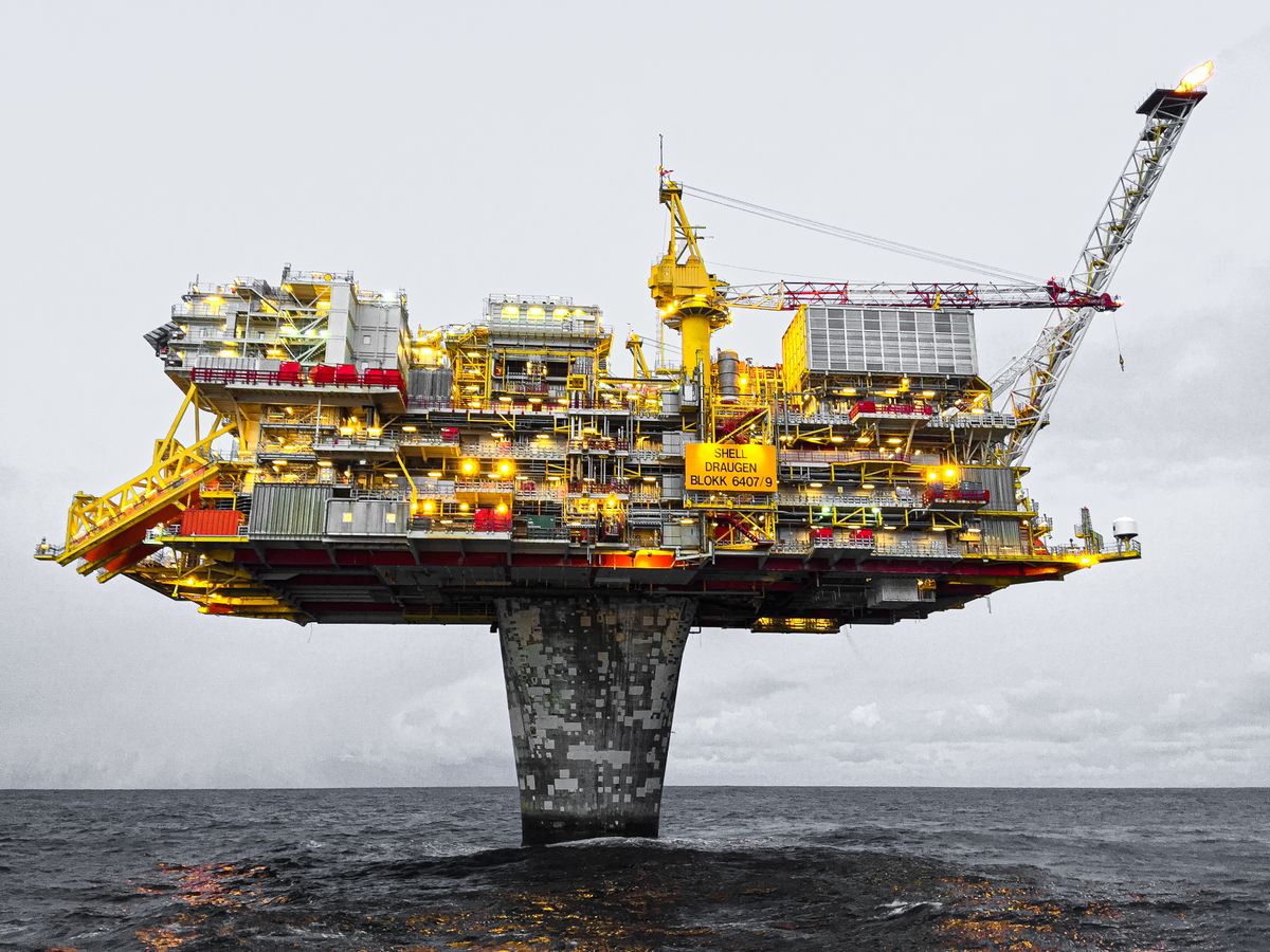 Plataforma de petróleo iluminada no mar, ilustrando o trabalho offshore