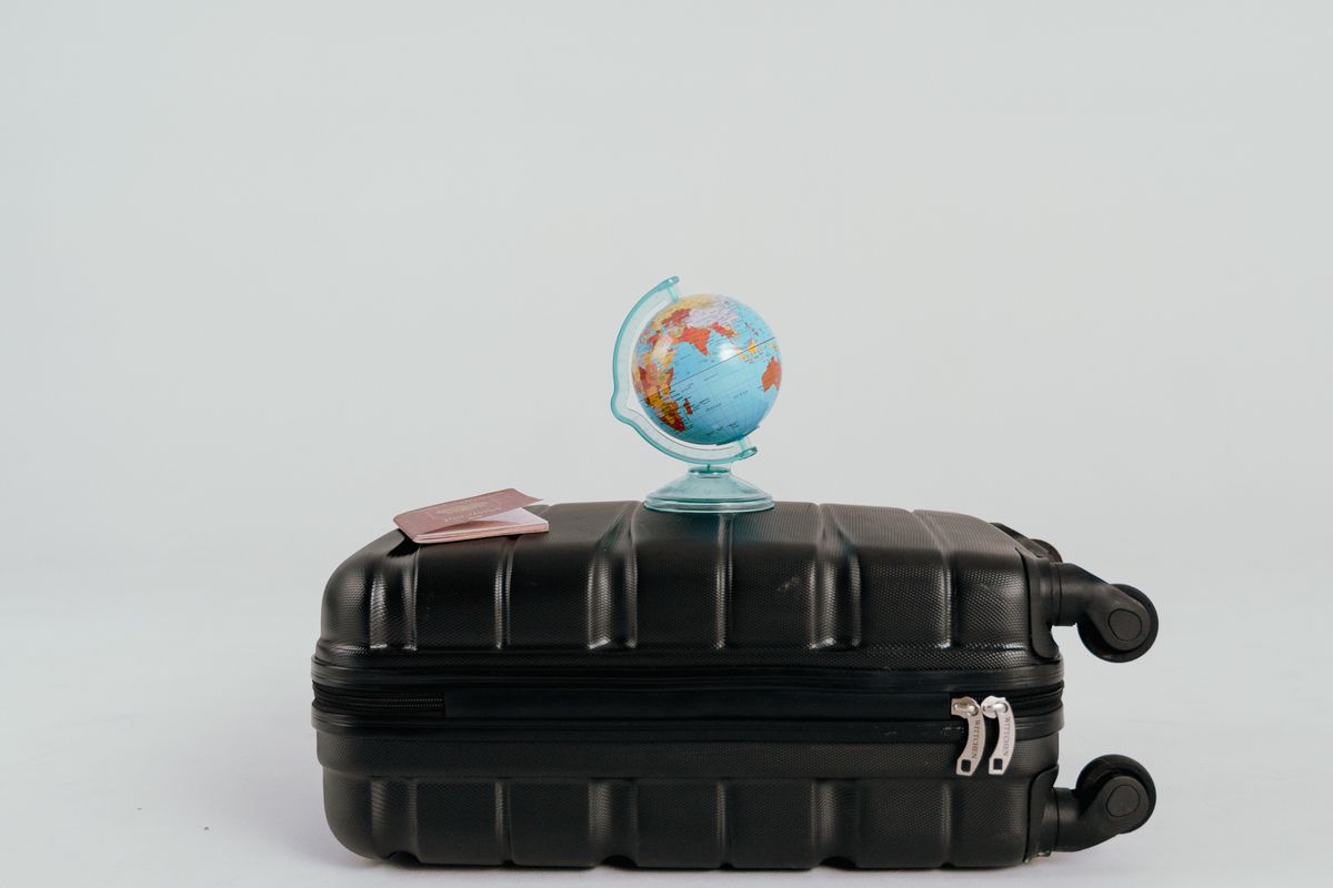 Globo sobre uma mala de viagem, ilustrando o tempo trabalhado no exterior e a aposentadoria pelo INSS